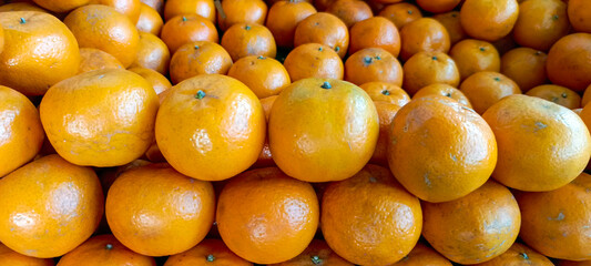A stack of canoes, Pakistani kenu, oranges on a market stall closeup stock photo