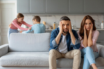 Overwhelmed parents and playful children at home