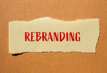Rebranding word written on ripped yellow paper with cardboard background. Conceptual symbol. Copy space.