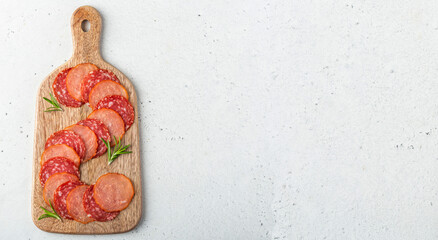 Overhead shot og a wooden serving board with two types of raw dries sausage