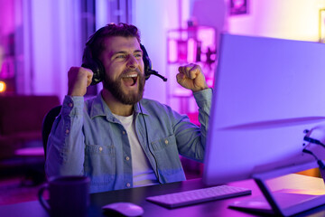 Man laughing while gaming at home in neon light