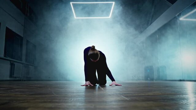 Elegant female dancing in dark studio with smoke and spotlight. Woman dancing indoors. Sensual choreography in smoky studio with beautiful light. High heels. 4K, UHD