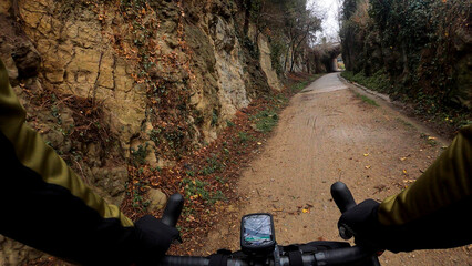 Riding a gravel bicycle on a wet muddy path on a mountain track rider point of view