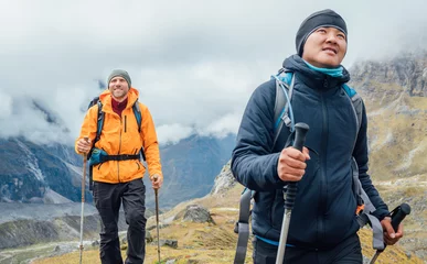 Foto auf Acrylglas Makalu Caucasian and Sherpa men backpackers with trekking poles together hiking and enjoying Mera peak climbing acclimatization walk Makalu Barun Park route. Men enjoying Togetherness and beautiful valley.