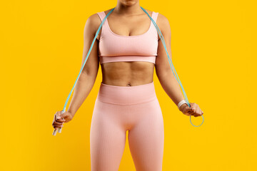 Fit lady with jump rope on yellow background - obrazy, fototapety, plakaty
