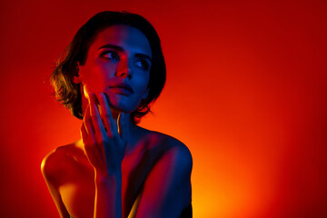 Photo of pretty dreamy woman naked shoulders hand arms cheek empty space isolated red neon color...