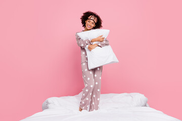 Photo of sweet shiny lady wear pajama smiling embracing pillow isolated pink color background