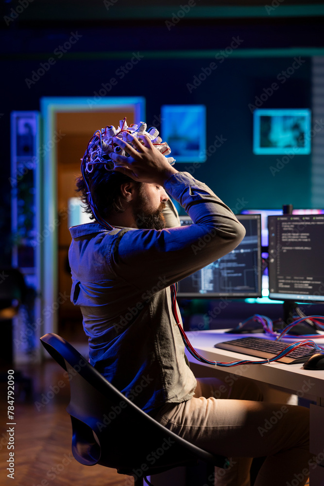 Poster software engineer puts eeg headset on, starting mind upload process, trying to gain bionic powers. i