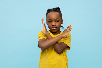 Strict African American little boy showing x-sign gesture