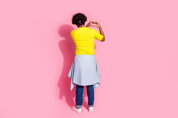 Rear view photo of funny kind man wear stylish yellow clothes showing heart sign isolated on pink color background