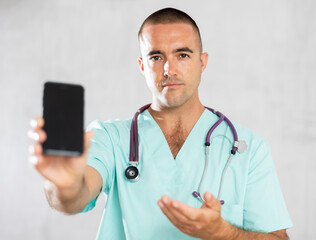 Doctor employs modern communication tools, using his phone to address medical inquiries.