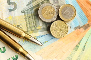 Yellow cartridges and shell casings on euro banknotes. Lot of bills of European union currency and...