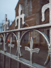 Metal decoration on a security fence outside catholic church. Selective focus. Blacksmith craft and...