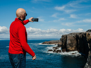 Tourist standing and enjoy view of stunning mini cliff in county Clare, Ireland. Travel and...