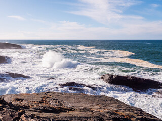 Rough stone coast of Ireland in bridges of Ross area in county Clare, Ireland. Popular tourist landmark area. Warm sunny day, cloudy sky, cliffs and rocks by the ocean. Epic Irish landscape.