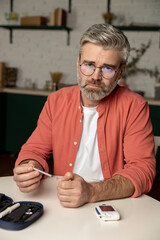Caucasian diabetic man with insulin syringe injection sitting at table
