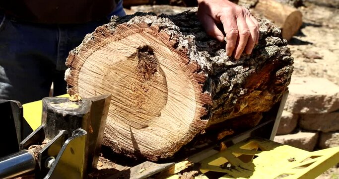 A video of a an cutting large oak pieces of wood with a log splitter.