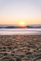 Soothing sunset view, waves meet sandy shore.