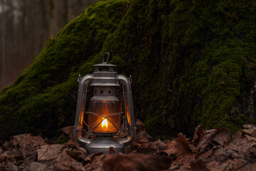 Fantasy kerosene lantern shining in green moss