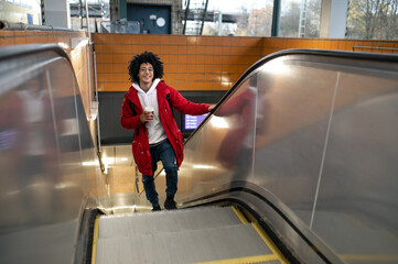 Young guy on the escalator at the railway station