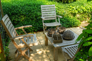 garden with wineware and wooden chairs  at Appeltern gardens - obrazy, fototapety, plakaty