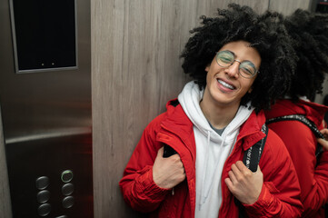 Smiling guy in red jacket in the elevator looking contented