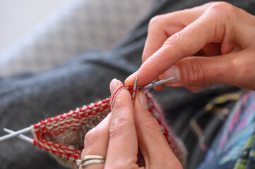Women's hands knit socks from yarn. Knitting socks is a great activity for women.