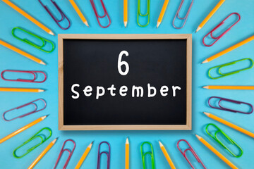 September 6 written in chalk on black board. Calendar date 6st of September on chalkboard on blue...