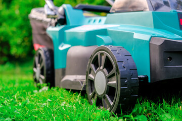 Lawn mower in summer garden. Mowing the grass in the garden.Garden equipment and tools.cutting grass  - 784830435