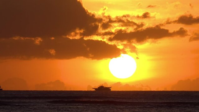 HAWAII - 3.19.2024 - A yacht sails past the sunset off the coast of Hawaii.