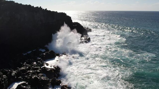 MOLOKAI - 3.19.2024 - Great aerial footage of waves crashing against the rocky shore of Molokai, Hawaii in slow motion.