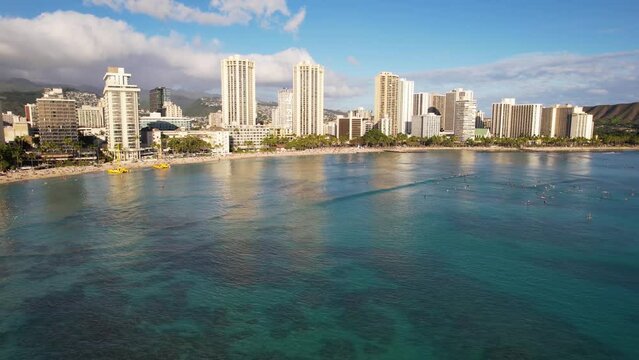 WAIKIKI - 3.19.2024 - Excellent aerial footage moving over waves rolling towards the shores of Waikiki, Hawaii.