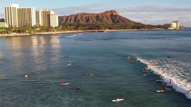WAIKIKI - 3.19.2024 - Great aerial view tracking surfers riding waves towards Waikiki, Hawaii.