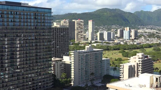 WAIKIKI - 3.19.2024 - Very good aerial footage of residential buildings and a mountain range in the background of Waikiki, Hawaii.