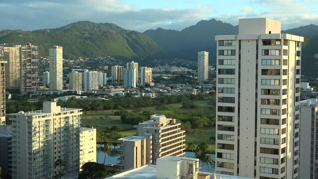 WAIKIKI - 3.19.2024 - Excellent aerial footage of tall buildings in a green valley of Waikiki, Hawaii.