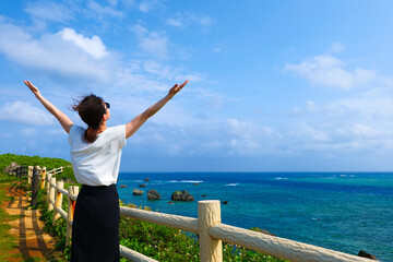 沖縄の海を眺める女性 - obrazy, fototapety, plakaty