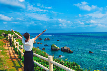 沖縄の海を眺める女性 - obrazy, fototapety, plakaty