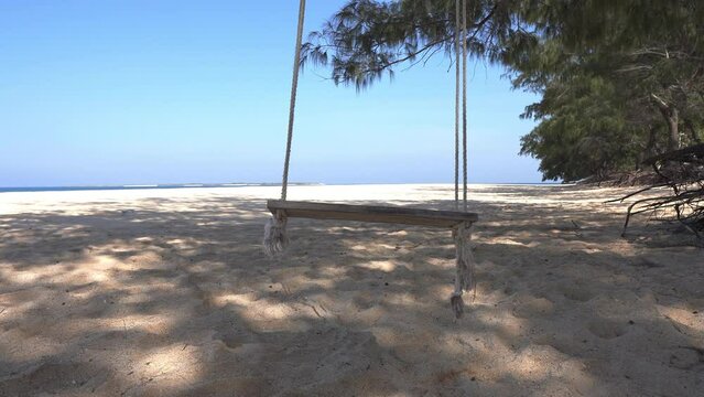Empty old swing on the beach.