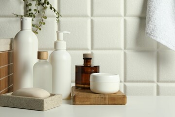 Fototapeta na wymiar Different bath accessories and personal care products on white table near tiled wall