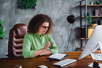 Photo of charming minded successful woman sitting in chair modern office writing notes workspace...