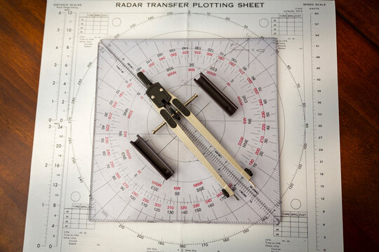 Above image of a navigator's radar plotting chart with a triangler and compass divider