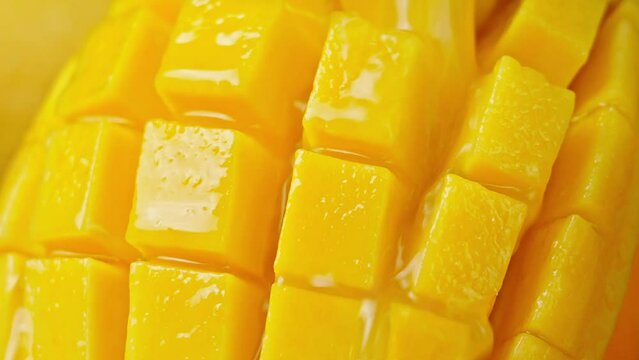 Slow Motion Shot of Mango Juice Splashing through Mango Cube Slices