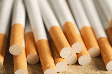 image of several commercially made pile cigarette on wood background. or Non smoking campaign concept, tobacco pattern top view