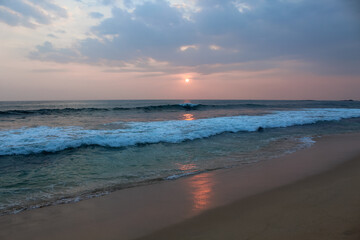 The sun setting into the sea at Delawella beach, Sri Lanka. Golden light