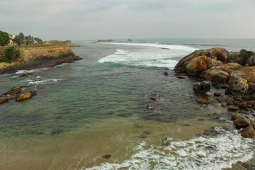 View of the waves crashing into the rocky shore of Sri Lanka