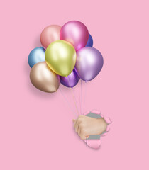 Childrens hand holding shiny colorful matte balloons through the hole in pink paper - 784889457