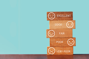emotion face on stack of wooden  block with indicator text on   blue background for evaluation,...