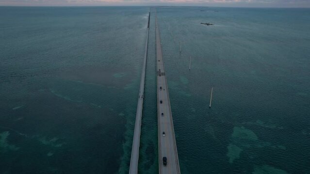 Seven Mile Bridge Tilt Up to Sunset in Florida Keys Aerial View. Fly Over American Bridge Over Blue Ocean Pastel Colored Sky