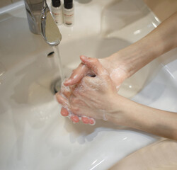 Hands washing with soap, top view.