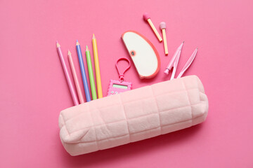 Pencil case with different school stationery on pink background
